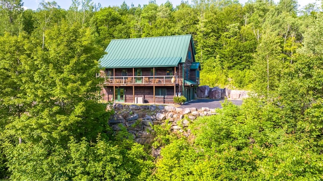 30 Hillside Dr, Kingfield, ME 04947 - back of house featuring a sunroom, a wooded view, a metal roof, and a wooden deck