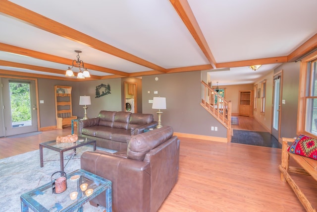30 Hillside Dr, Kingfield, ME 04947 - living room with washer / dryer, light wood-style floors, beam ceiling, stairway, and a chandelier