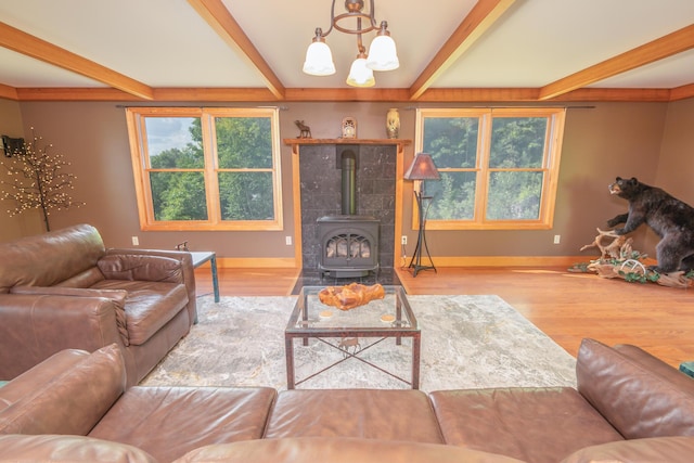 30 Hillside Dr, Kingfield, ME 04947 - living room featuring beam ceiling, a chandelier, a wood stove, plenty of natural light, and wood finished floors