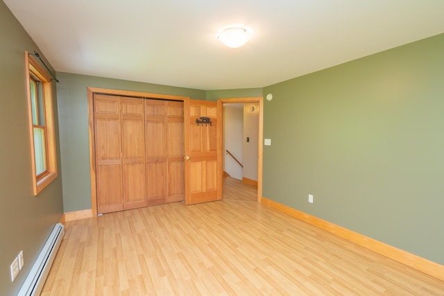 30 Hillside Dr, Kingfield, ME 04947 - unfurnished bedroom featuring a baseboard heating unit, light wood finished floors, and a closet