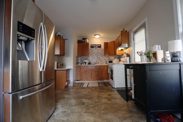 41 Dunn St, Auburn, ME 04210 - kitchen featuring white appliances, under cabinet range hood, brown cabinetry, light countertops, and backsplash