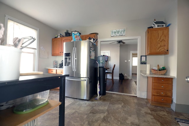 41 Dunn St, Auburn, ME 04210 - kitchen with stainless steel fridge, light countertops, brown cabinets, and dark stone finish flooring