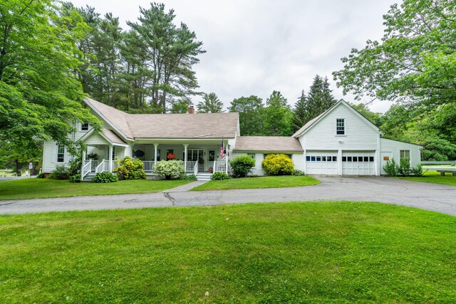 22 River Rd, Dresden, ME 04342 - view of front of house with a porch, a chimney, a front lawn, asphalt driveway, and a garage
