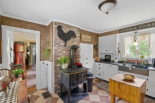 22 River Rd, Dresden, ME 04342 - kitchen featuring stainless steel dishwasher, a wood stove, wallpapered walls, ornamental molding, and dark countertops