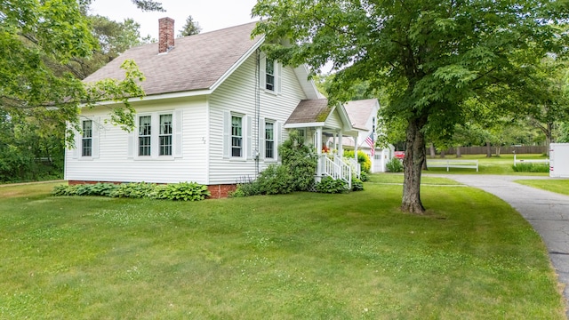 22 River Rd, Dresden, ME 04342 - view of home's exterior with a chimney, a yard, and roof with shingles