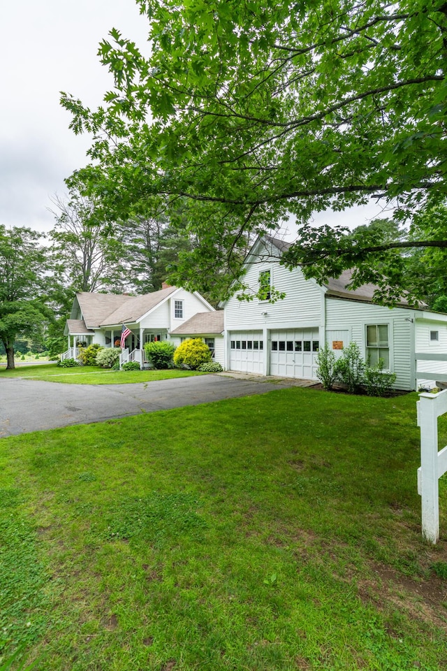 22 River Rd, Dresden, ME 04342 - view of front facade with asphalt driveway, a garage, and a front yard