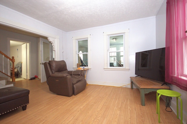 30 Burnham St, Old Town, ME 04468 - living room with stairs, light wood-style flooring, a textured ceiling, and crown molding
