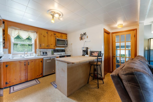 911 Spring St, Westbrook, ME 04092 - kitchen with appliances with stainless steel finishes, open floor plan, a kitchen breakfast bar, butcher block countertops, and brown cabinets