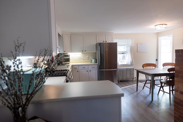 55 Ossipee Trl E, Standish, ME 04084 - kitchen with stainless steel appliances, radiator, tasteful backsplash, dark wood-type flooring, and white cabinets