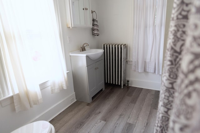 55 Ossipee Trl E, Standish, ME 04084 - bathroom with radiator heating unit, vanity, and wood finished floors
