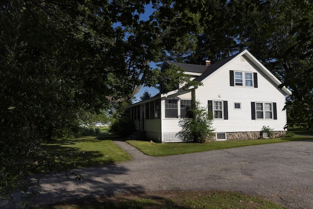 55 Ossipee Trl E, Standish, ME 04084 - view of home's exterior with a chimney, a sunroom, and a lawn
