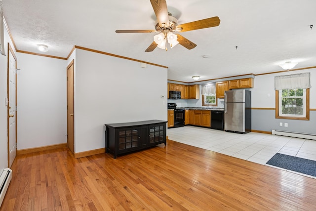 24 Maple Ridge Rd, Gorham, ME 04038 - kitchen with black appliances, a baseboard heating unit, brown cabinetry, light wood-style floors, and crown molding