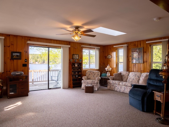 16 Hide Away Ln, Milton, NH 03851 - living room featuring carpet, wooden walls, a ceiling fan, and a skylight