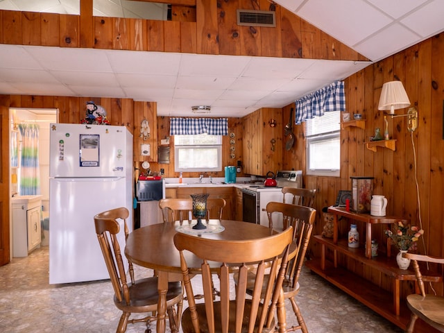 16 Hide Away Ln, Milton, NH 03851 - dining room featuring wood walls, a drop ceiling, healthy amount of natural light, and light floors