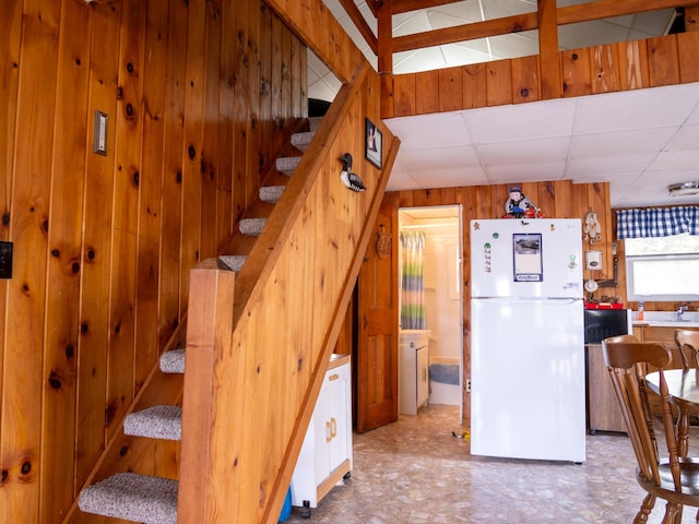 16 Hide Away Ln, Milton, NH 03851 - kitchen with freestanding refrigerator, wood walls, and a drop ceiling