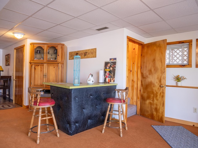 16 Hide Away Ln, Milton, NH 03851 - kitchen featuring a drop ceiling, carpet floors, a breakfast bar, glass insert cabinets, and brown cabinets