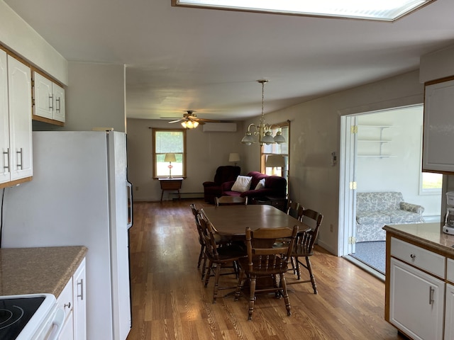 68 Stetson Rd, Newport, ME 04953 - dining area featuring wood finished floors, a wall mounted air conditioner, ceiling fan, and a chandelier