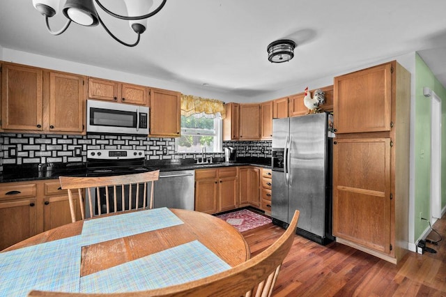 93 Bartlett Rd, Kittery, ME 03905 - kitchen featuring appliances with stainless steel finishes, dark countertops, dark wood-type flooring, and tasteful backsplash