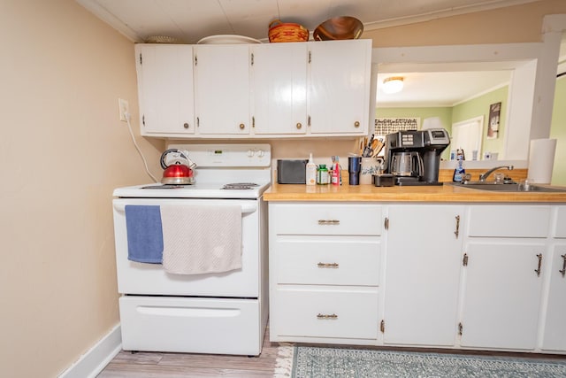 57 Main St, Sangerville, ME 04479 - kitchen with electric stove, crown molding, light wood-type flooring, white cabinetry, and light countertops