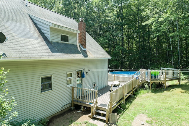 64 Pond View Dr, Otisfield, ME 04270 - rear view of house featuring a deck, a chimney, an outdoor pool, and a yard