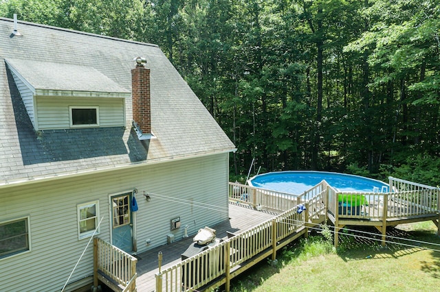 64 Pond View Dr, Otisfield, ME 04270 - view of side of home featuring a chimney, a deck, an outdoor pool, and roof with shingles