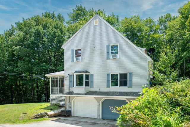 64 Pond View Dr, Otisfield, ME 04270 - view of front of home with an attached garage, a front lawn, a sunroom, cooling unit, and driveway