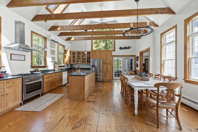 416 River Rd, Edgecomb, ME 04556 - kitchen featuring appliances with stainless steel finishes, wall chimney range hood, dark countertops, light wood-style flooring, and a kitchen island