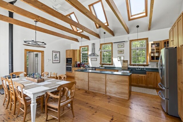 416 River Rd, Edgecomb, ME 04556 - kitchen featuring stainless steel appliances, wall chimney range hood, dark countertops, beam ceiling, and glass insert cabinets
