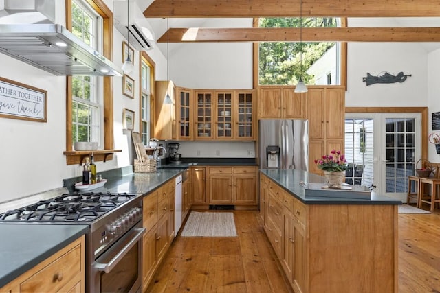 416 River Rd, Edgecomb, ME 04556 - kitchen with stainless steel appliances, high vaulted ceiling, dark countertops, a wall mounted air conditioner, and light wood finished floors