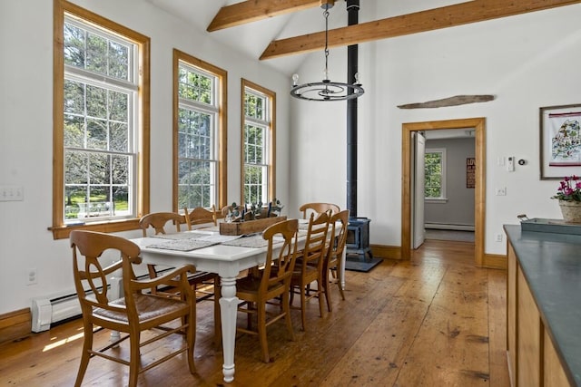 416 River Rd, Edgecomb, ME 04556 - dining area with a wood stove, light wood finished floors, a chandelier, and a baseboard radiator