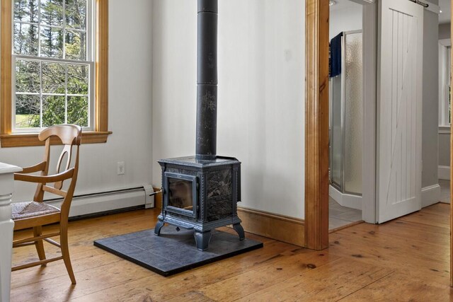 416 River Rd, Edgecomb, ME 04556 - detailed view of a baseboard radiator, a wood stove, and wood finished floors