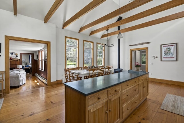 416 River Rd, Edgecomb, ME 04556 - kitchen featuring dark countertops, a baseboard radiator, light wood-style floors, decorative light fixtures, and a center island