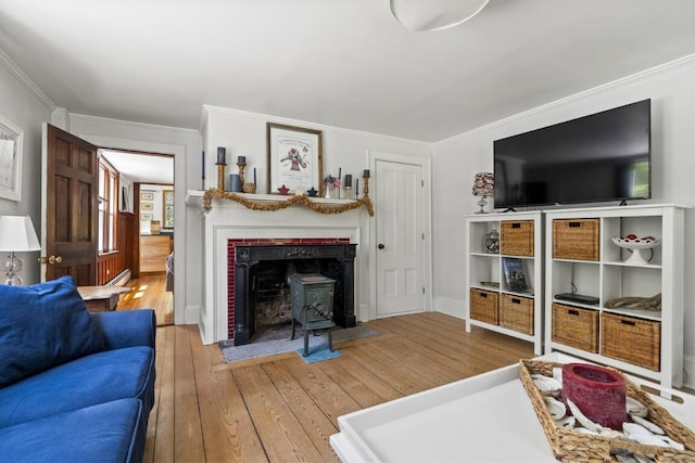 416 River Rd, Edgecomb, ME 04556 - living area featuring wood-type flooring, crown molding, and a wood stove