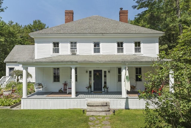 416 River Rd, Edgecomb, ME 04556 - farmhouse with roof with shingles, a front yard, a chimney, and covered porch