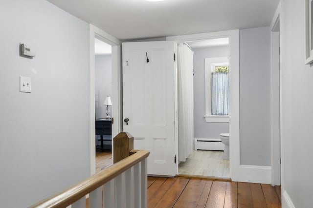 416 River Rd, Edgecomb, ME 04556 - hall with baseboard heating, hardwood / wood-style flooring, and an upstairs landing