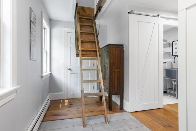 416 River Rd, Edgecomb, ME 04556 - hallway with a barn door, light tile patterned floors, plenty of natural light, and a baseboard heating unit