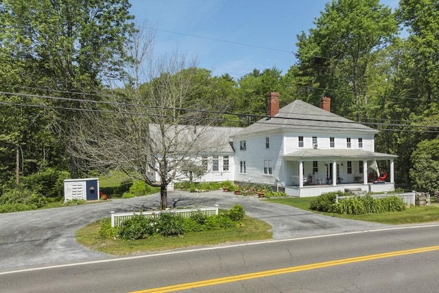 416 River Rd, Edgecomb, ME 04556 - view of front of property featuring a porch, a chimney, curved driveway, and roof with shingles