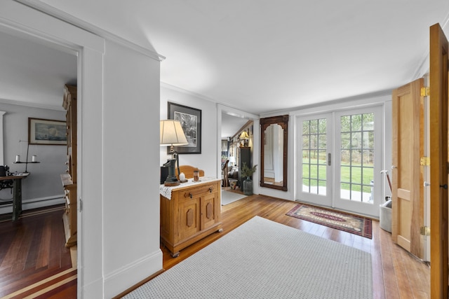 259 Mountain St, Camden, ME 04843 - entrance foyer with light wood-style floors, ornamental molding, and a baseboard heating unit