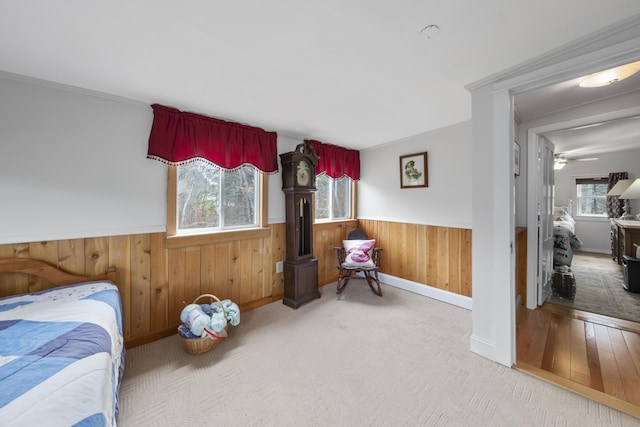 259 Mountain St, Camden, ME 04843 - carpeted bedroom featuring wainscoting, multiple windows, wood walls, and a wood stove