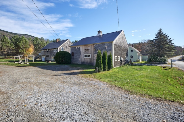 259 Mountain St, Camden, ME 04843 - view of property exterior with a metal roof, a yard, and gravel driveway