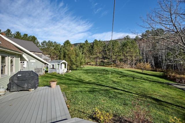 259 Mountain St, Camden, ME 04843 - view of green lawn featuring a deck, a storage shed, and a wooded view