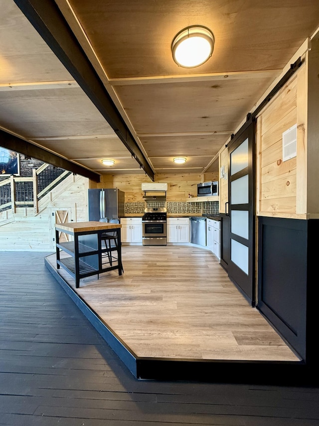 339 Main St, Calais, ME 04619 - unfurnished dining area featuring light wood finished floors, a barn door, wooden walls, and wood ceiling
