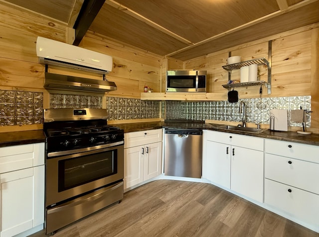 339 Main St, Calais, ME 04619 - kitchen with appliances with stainless steel finishes, dark countertops, tasteful backsplash, white cabinets, and wooden walls