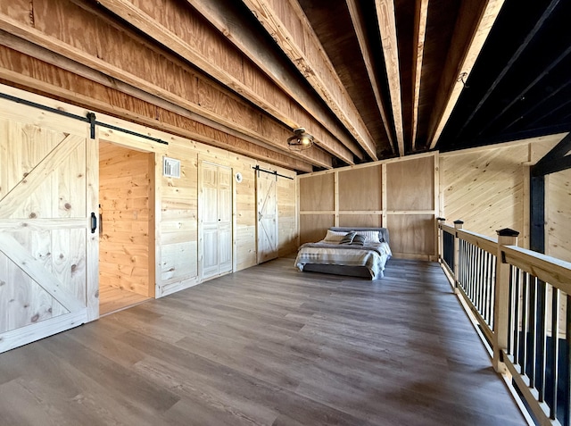 339 Main St, Calais, ME 04619 - bedroom featuring a barn door, wood walls, and wood finished floors