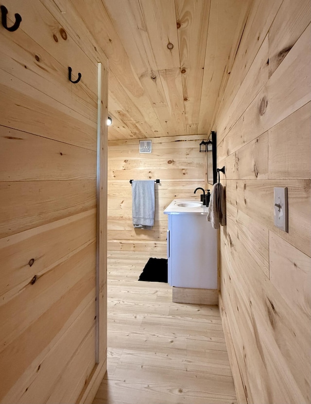 339 Main St, Calais, ME 04619 - bathroom with wood walls, wooden ceiling, vanity, and hardwood / wood-style flooring