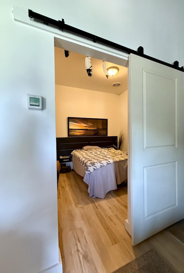 339 Main St, Calais, ME 04619 - bedroom with a barn door and wood finished floors