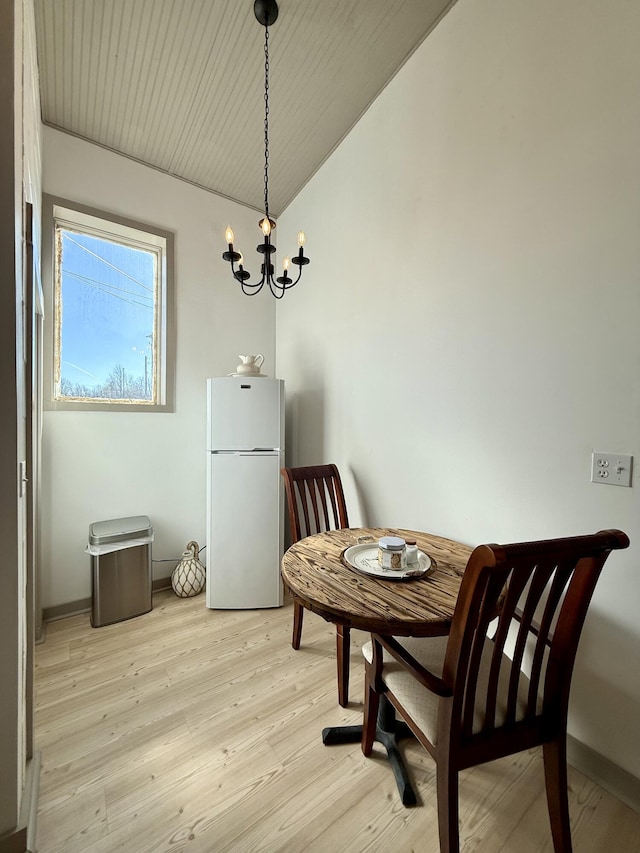 339 Main St, Calais, ME 04619 - dining area with a chandelier, light wood-style floors, and vaulted ceiling