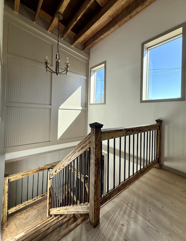 339 Main St, Calais, ME 04619 - stairway with a chandelier, beam ceiling, and wood finished floors