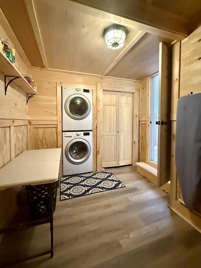 339 Main St, Calais, ME 04619 - laundry area featuring stacked washing machine and dryer, wooden walls, and light wood-type flooring