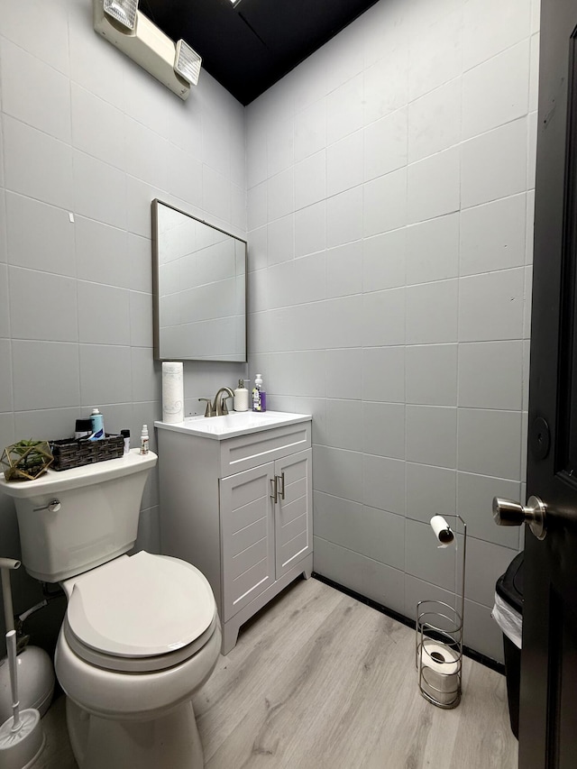 339 Main St, Calais, ME 04619 - half bathroom featuring tile walls, wood finished floors, and vanity